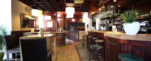 a bar with a bunch of stools in a restaurant at Best Western Le Pont d'Or in Figeac