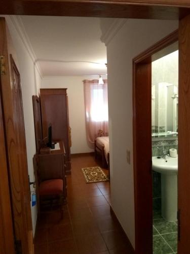 a room with a bathroom with a sink and a bed at Joaquim do Norte in Podence