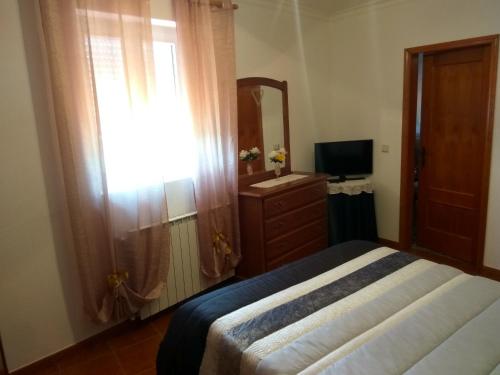 a bedroom with a bed and a dresser and a mirror at Joaquim do Norte in Podence