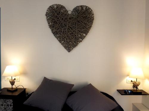 a heart hanging on a wall next to a bed at SilMar in Camogli