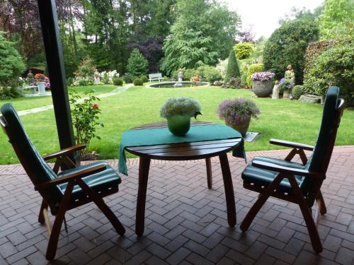 a table with a vase on top of it with two chairs at Ferien im Königshaus in Möhnesee