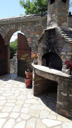 a stone fireplace in a patio with some potted plants at Archontiko Koilia in Makrinítsa