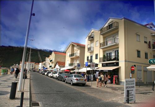 eine Straße mit Autos, die an der Seite eines Gebäudes geparkt sind in der Unterkunft Flipflops Ocean View in Nazaré