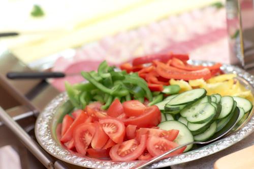 a plate of food with tomatoes cucumbers and other vegetables at Ev.Familienferien-und Bildungsstätte Ebernburg in Bad Münster am Stein-Ebernburg