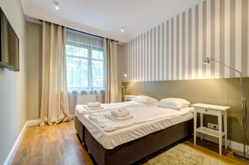 a bedroom with a large bed and a window at Dom & House - Apartment Neptun Park Premium in Jelitkowo