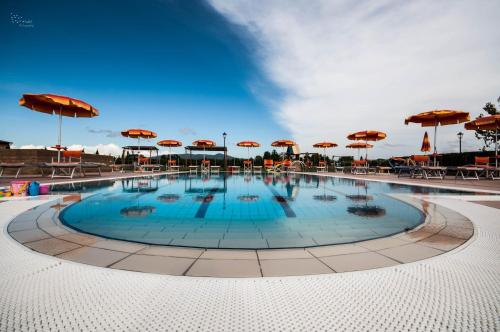 a large pool with umbrellas and tables and chairs at Borgo Verde in Vada