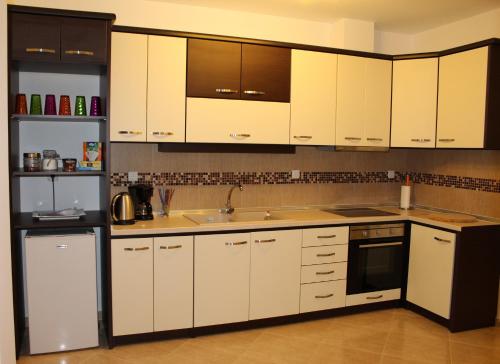 a kitchen with white cabinets and a sink at Villa Dimitri - GardenSide Souterrain in Alexandroupoli