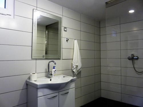 a white bathroom with a sink and a mirror at Apartman in Cres