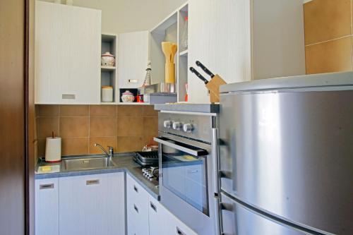 La cuisine est équipée d'une cuisinière en acier inoxydable et d'un réfrigérateur. dans l'établissement La Pineta, à Stresa