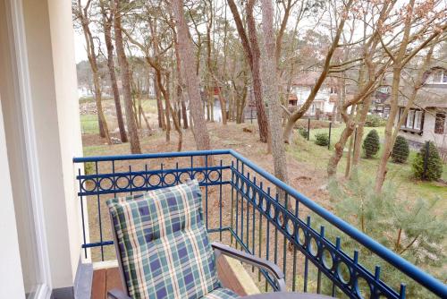 a balcony with a chair and a view of trees at Baabe Grüne Düne Fewo Sommerfrische - 13 (Ref.199157) in Baabe