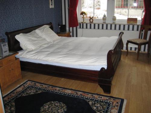 a bedroom with a bed with white sheets and a rug at Leibniz6 Stilvolles Privatzimmer in Leipzig