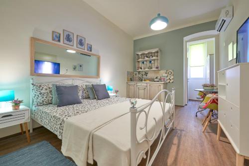 a bedroom with a white bed and a kitchen at Old City Romanitic Studios 1 with FREE private parking in Pula