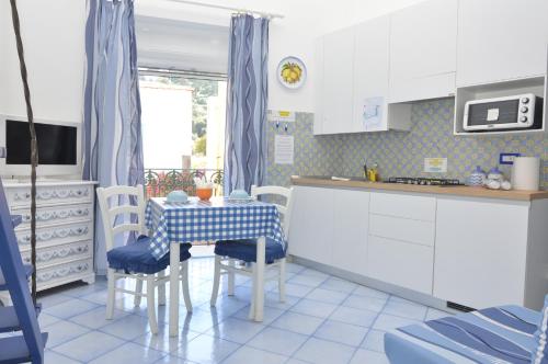 a kitchen with a table and chairs in a kitchen at Central Studio Capri in Capri