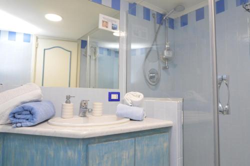 y baño azul con lavabo y ducha. en Central Studio Capri, en Capri