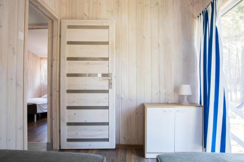 a bedroom with a door leading into a room with a bed at Archipelag in Ustka