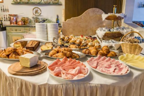 a table topped with lots of different types of food at Hotel Alla Posta - Famiglia Pra dal 1866 a Caprile in Alleghe