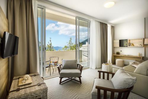 a living room with a couch and a large window at Aminess Lume Hotel in Brna