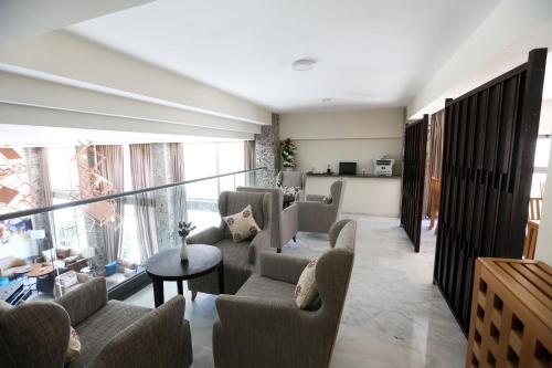 a living room with couches and chairs and a balcony at Hôtel du Golf Mohammedia in Mohammedia