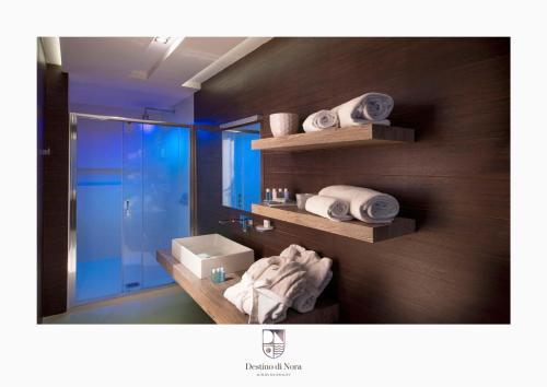 a bathroom with a sink and a mirror and towels at Destino di Nora in Pula