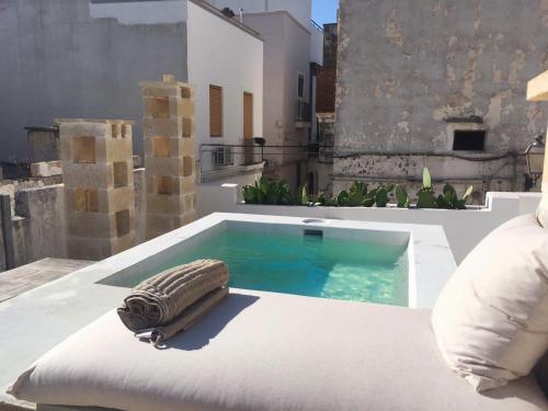 a swimming pool with a bed and a pillow on a patio at Riad Salentino by Acqua di Puglia in Matino