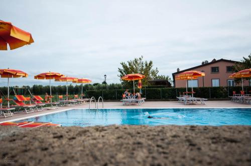 a swimming pool with tables and chairs and umbrellas at Borgo Verde in Vada