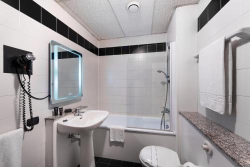 a bathroom with a sink and a toilet and a tub at JR Hotels Bologna Amadeus in Bologna