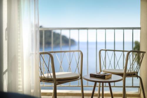 two chairs and a table in front of a balcony at Aminess Younique Lume Hotel in Brna