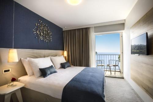 a hotel room with a bed and a balcony at Aminess Younique Lume Hotel in Brna