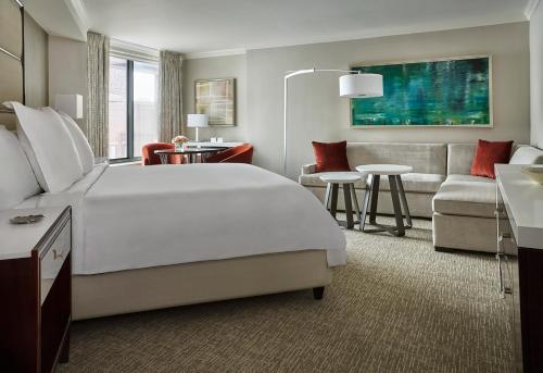 a hotel room with a large bed and a living room at Four Seasons Washington DC in Washington