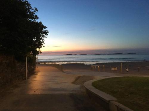 een strand bij zonsondergang met de oceaan op de achtergrond bij Family home sleeps 6 plenty of parking in Portrush