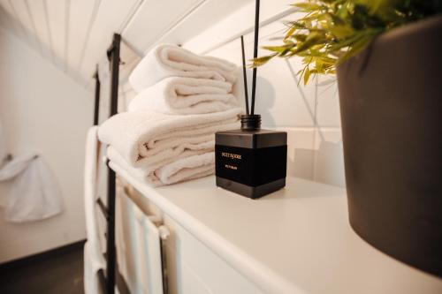 uma prateleira branca com toalhas e uma caixa preta em Harbour House em Hamburgsund