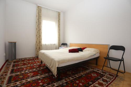 a bedroom with a bed with a rug and a window at Apartments Villa Irma in Sarajevo