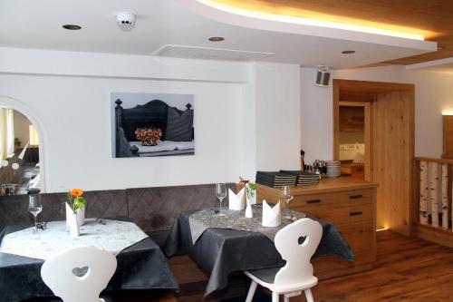 a dining room with a table and chairs and a kitchen at Hotel Tradizio in Mittelberg