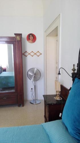a bedroom with a blue bed and a mirror at Villa Longo de Bellis in Bari