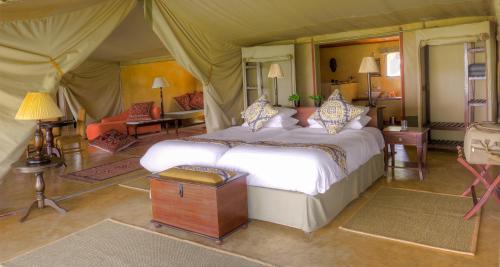 um quarto com uma cama numa tenda em Entumoto Main Camp em Ololaimutiek