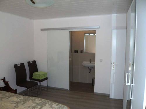 a bedroom with a bed and a bathroom with a sink at Ferienwohnung Moselblick in Ediger-Eller