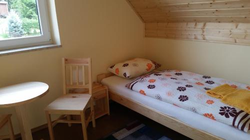 a small bedroom with a bed and a window at Domki letniskowe Yaga in Wilkasy