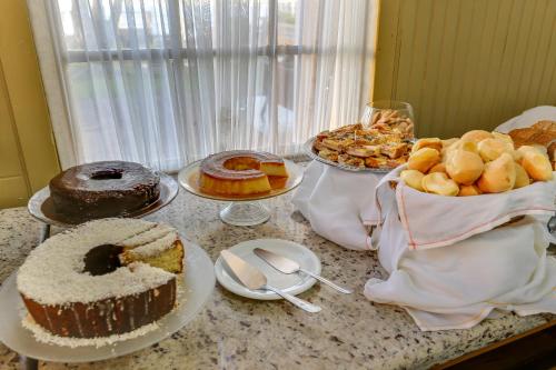 a table with many different types of cakes and pastries at Canasvieiras Hotel in Florianópolis