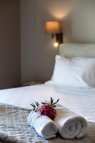 a towel with a flower on a bed at Summer Dream Lefkas in Lefkada Town