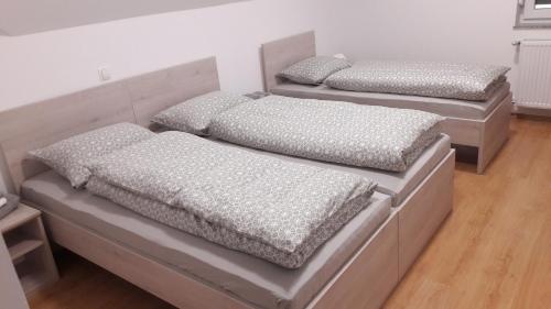 2 Betten mit Kissen auf einem Zimmer in der Unterkunft Gostilna Marta in Osluševci