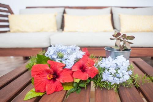 a table with red and white flowers on it at Pompei Suite in Pompei