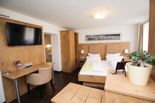 ein Hotelzimmer mit einem Bett und einem TV an der Wand in der Unterkunft Ferienwohnung am Griesgarten in Bamberg