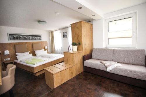 a room with two beds and a couch and a window at Ferienwohnung am Griesgarten in Bamberg