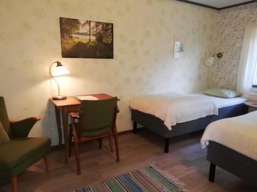 a hotel room with a bed and a desk and a chair at STF Långasjö Vandrarhem in Långasjö