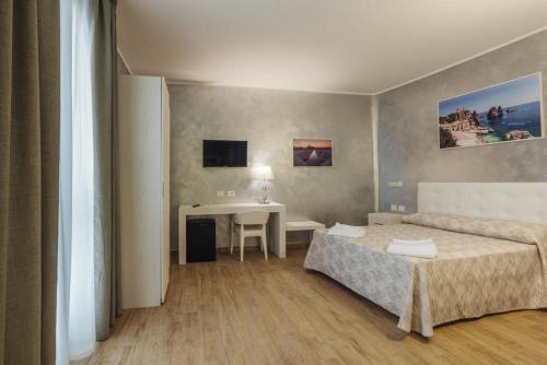 a room with two beds and a desk in it at Le Vele di Balestrate in Balestrate