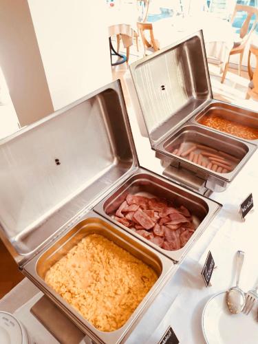 three trays of food on top of a table at Hotel Royal in Stresa