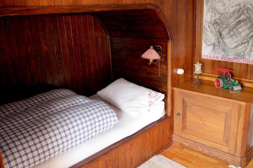 a small bed in a wooden room with a lamp at Haus Poxleitner in Mauth