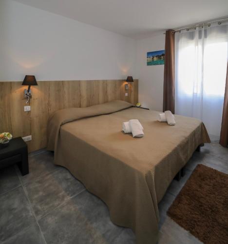 a bedroom with a bed with two pillows on it at L'Escale in Bonifacio