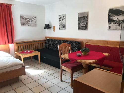 a room with a couch and a table and a bed at Appartements Kröll, Joker Card in summer included! in Saalbach Hinterglemm