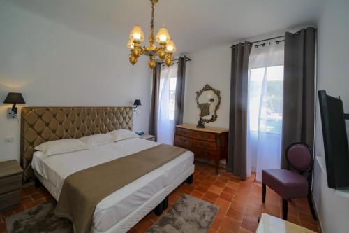 - une chambre avec un grand lit et un miroir dans l'établissement L'Escale, à Bonifacio